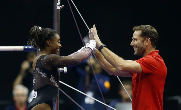 KANSAS CITY, MISSOURI - AUGUST 11: Simone Biles high-fives coach Laurent Landi after winning the all-around gold medal in the Women's Senior competition of the 2019 U.S. Gymnastics Championships at the Sprint Center on August 11, 2019 in Kansas City, Missouri. (Photo by Jamie Squire/Getty Images)