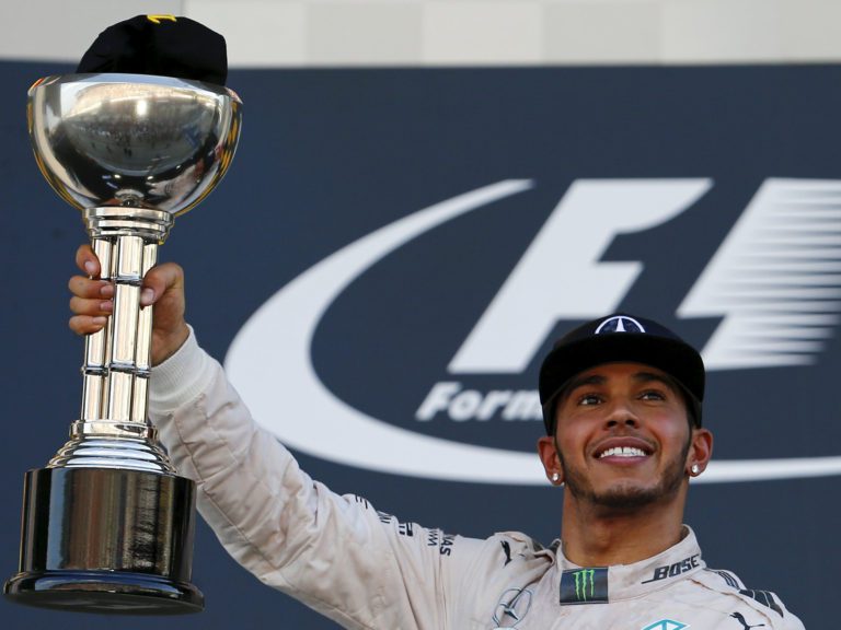 Lewis Hamilton levantando troféu homenageia senna